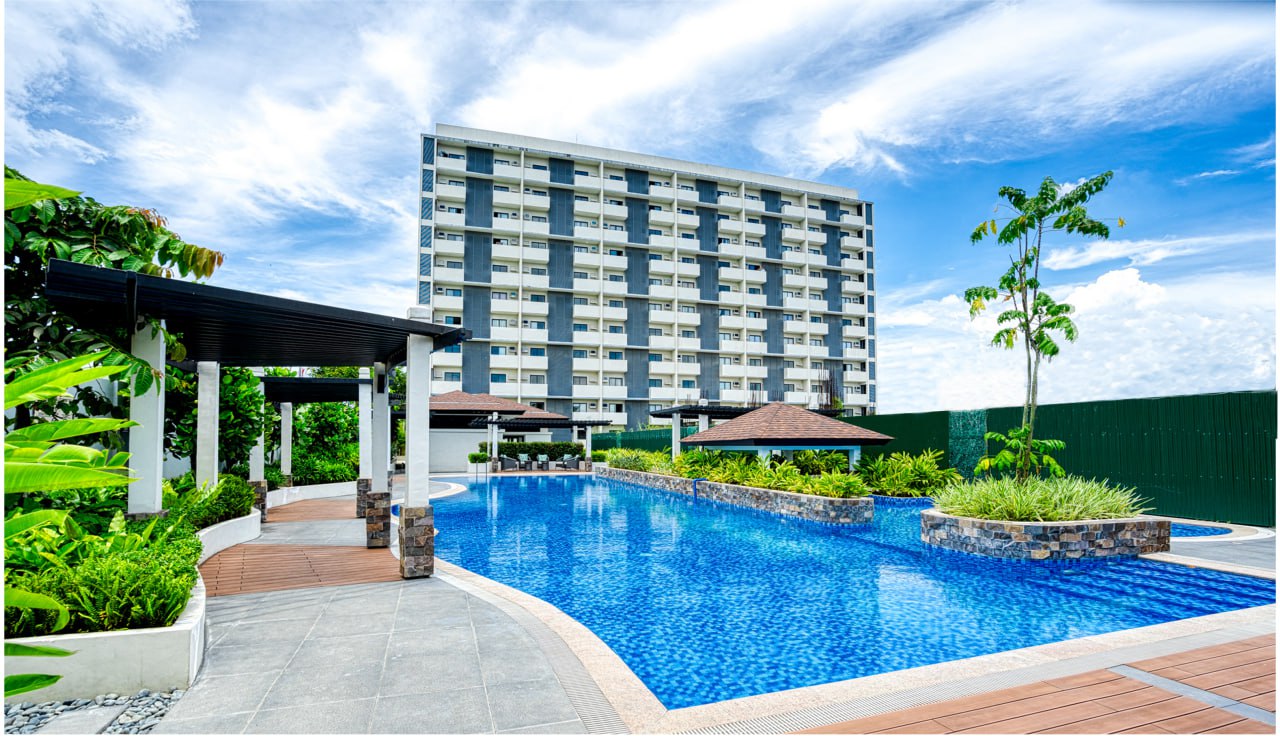 a swimming pool condo amenity with a building in the background