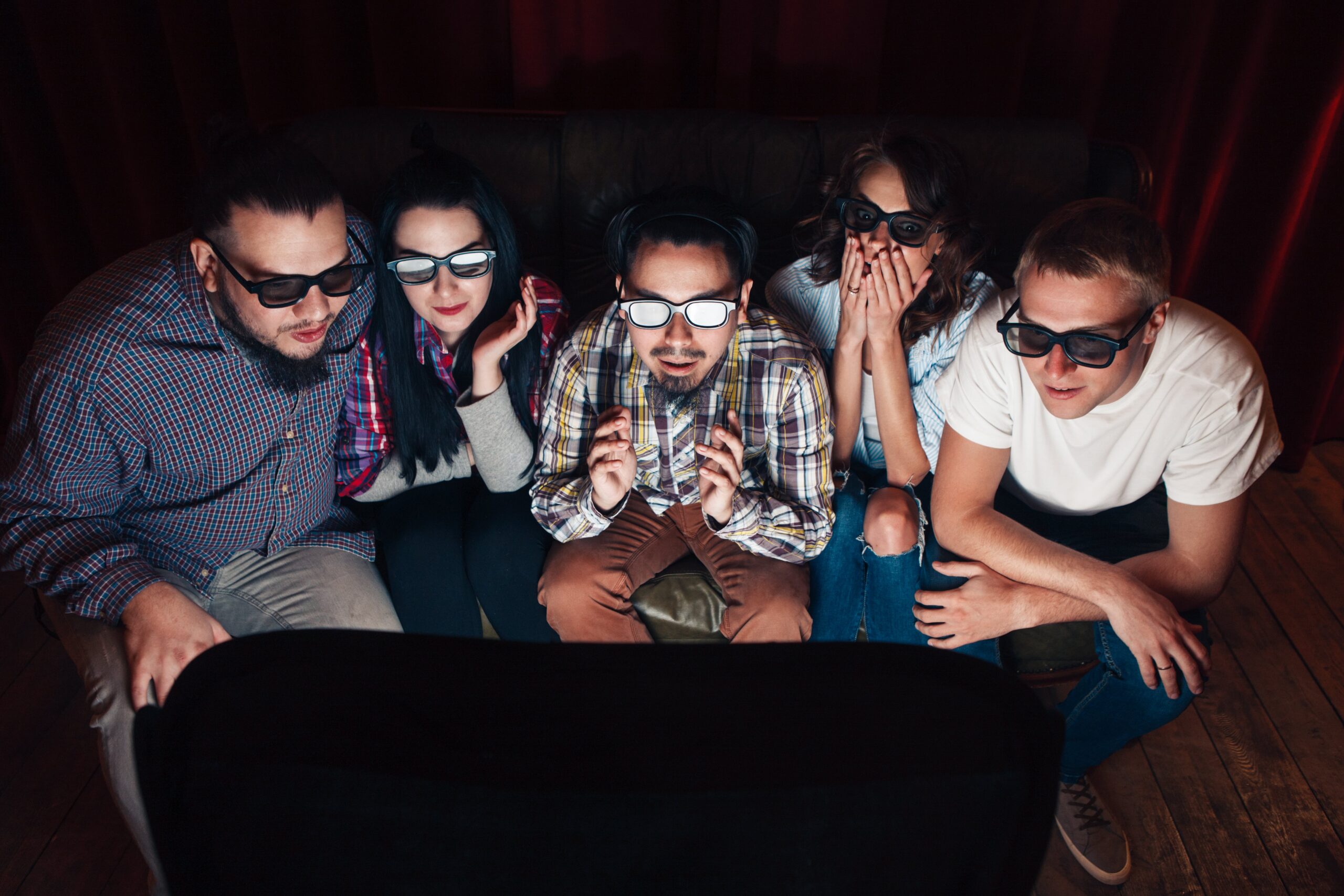 young people in 3d glasses watching movie on couch