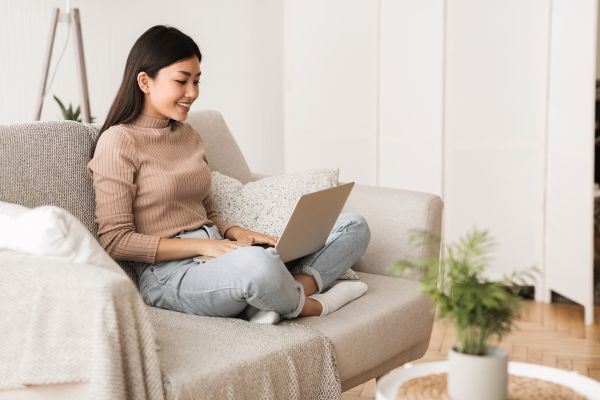 Woman using laptop while sitting comfortably on a sofa