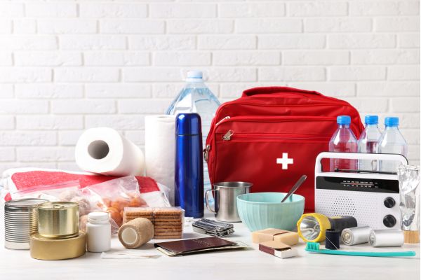 Emergency preparedness kit with food, water, first aid bag, and supplies.